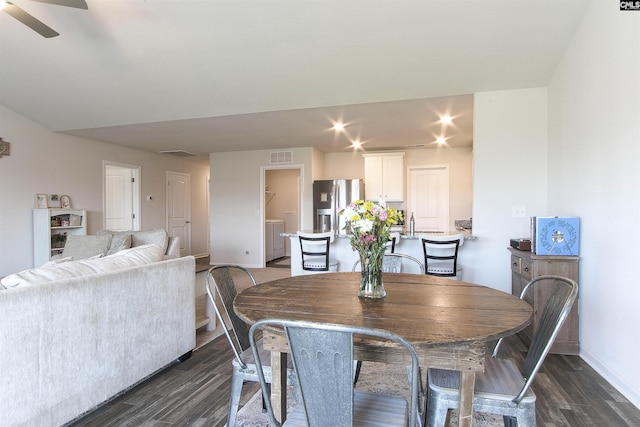 dining area featuring visible vents, a ceiling fan, dark wood finished floors, and baseboards