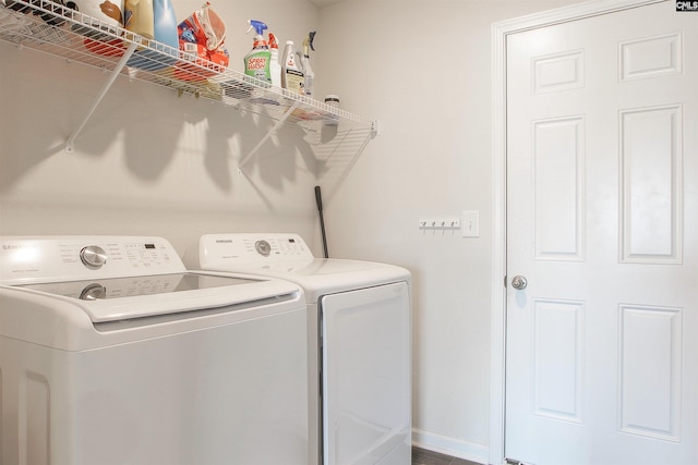 washroom with baseboards, laundry area, and washer and clothes dryer