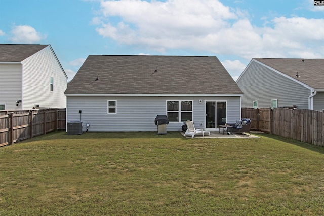 back of property featuring a lawn, a fenced backyard, a patio area, and a shingled roof