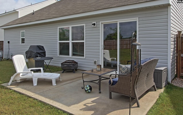 rear view of house featuring a fire pit, a shingled roof, and a patio area