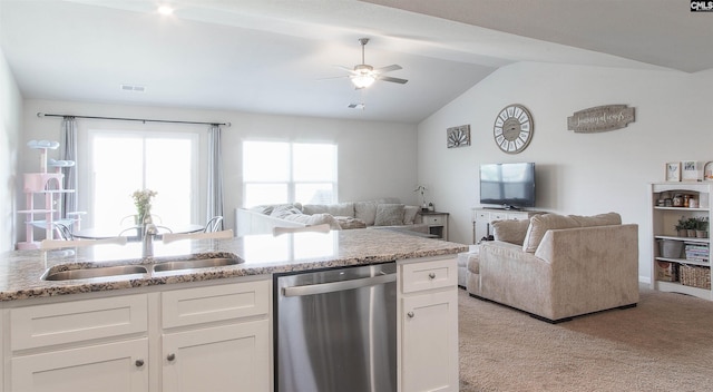 kitchen featuring stainless steel dishwasher, open floor plan, light colored carpet, white cabinetry, and a sink