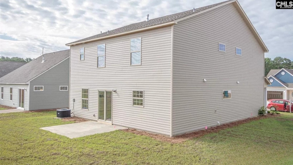 rear view of house with a patio area, central air condition unit, and a yard