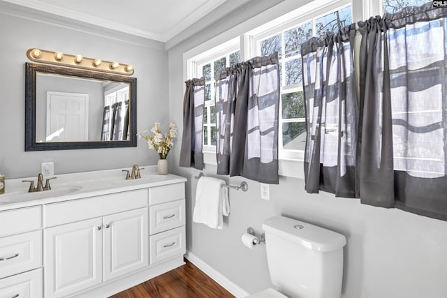 full bath with crown molding, toilet, a sink, and double vanity