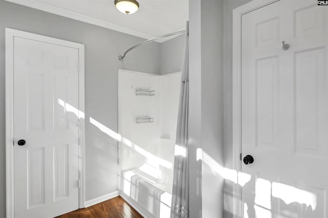 interior space with baseboards, ornamental molding, and wood finished floors