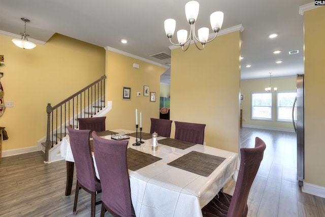 dining space with crown molding, a chandelier, stairs, and visible vents