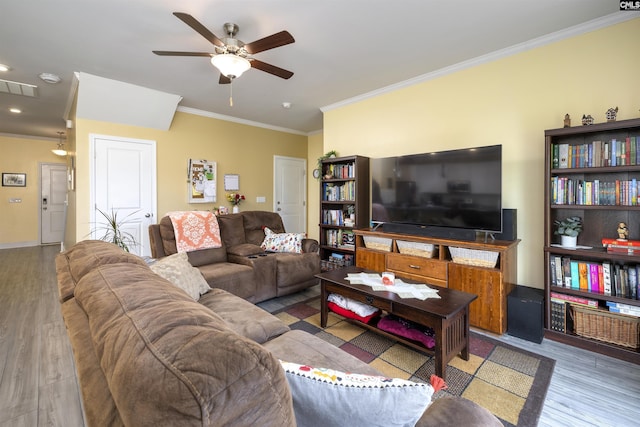 living room with crown molding, a ceiling fan, wood finished floors, and visible vents