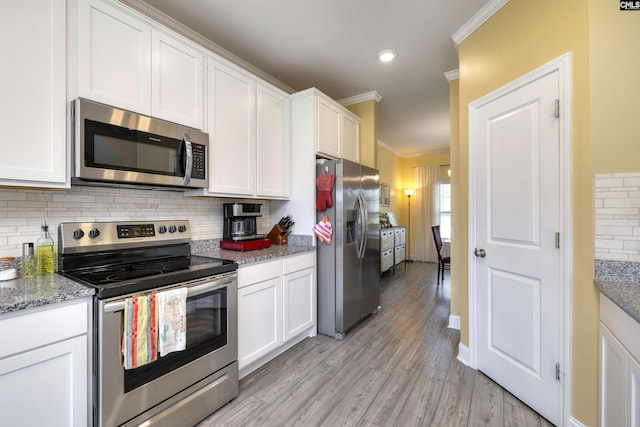 kitchen featuring appliances with stainless steel finishes, white cabinetry, baseboards, backsplash, and ornamental molding