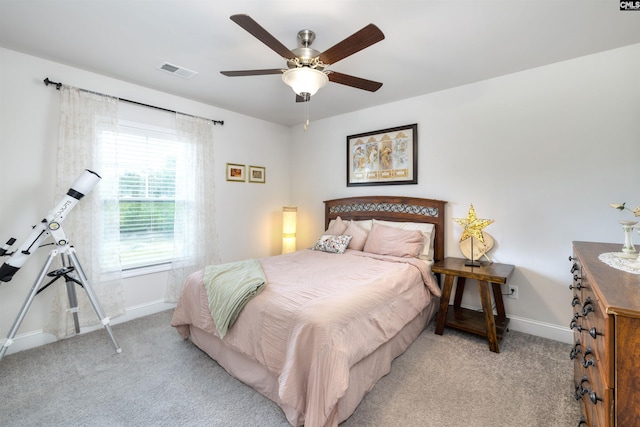 bedroom with visible vents, a ceiling fan, baseboards, and light carpet