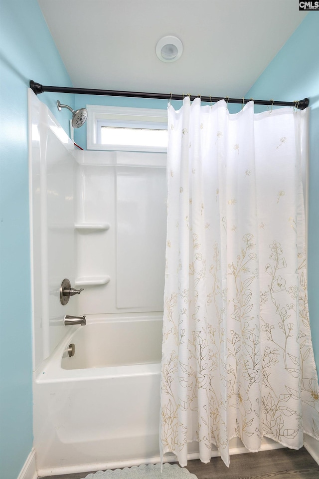 full bath featuring wood finished floors and shower / bath combination with curtain