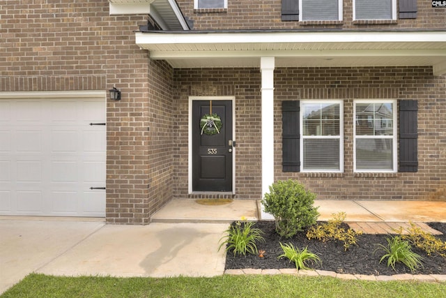 doorway to property featuring brick siding and a porch