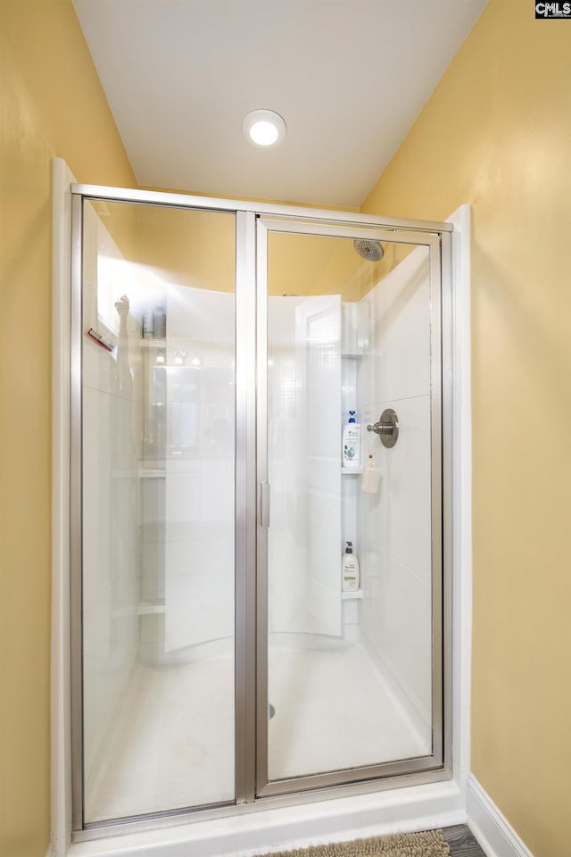 bathroom featuring baseboards and a shower stall