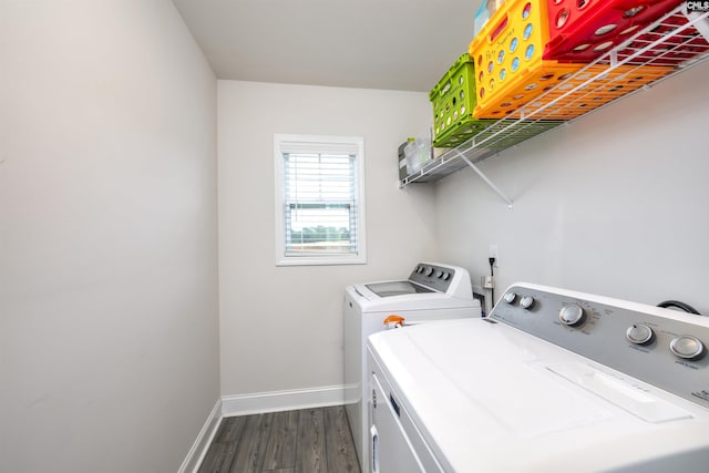 clothes washing area featuring laundry area, washer and clothes dryer, dark wood finished floors, and baseboards