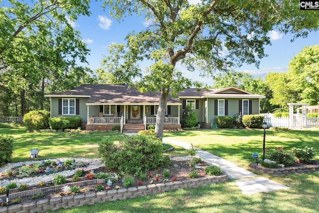 ranch-style house with fence, covered porch, and a front lawn