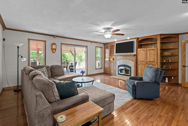 living area with crown molding, baseboards, and ceiling fan