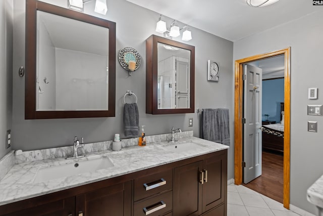 ensuite bathroom featuring double vanity, a sink, connected bathroom, and tile patterned floors