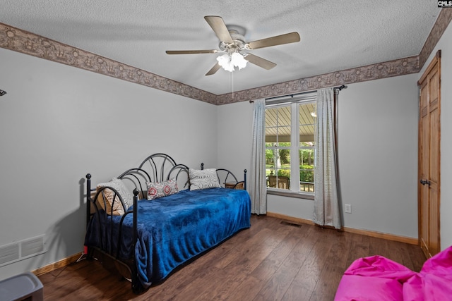 bedroom featuring baseboards, wood-type flooring, a textured ceiling, and visible vents