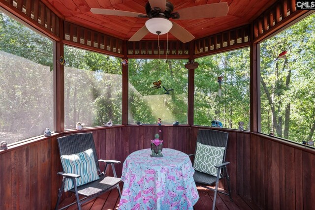sunroom / solarium featuring outdoor dining area, ceiling fan, and a wealth of natural light