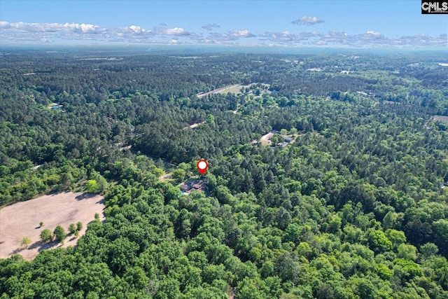 birds eye view of property featuring a forest view