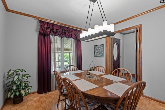 dining space featuring crown molding, baseboards, and a notable chandelier