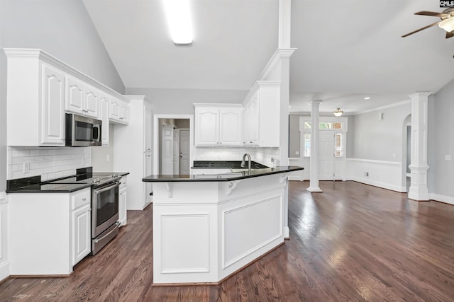 kitchen featuring a sink, dark countertops, stainless steel appliances, and a peninsula
