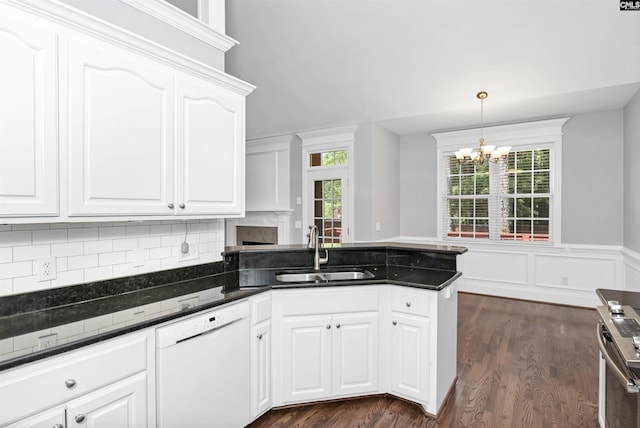 kitchen featuring electric range, a peninsula, white dishwasher, a sink, and a notable chandelier