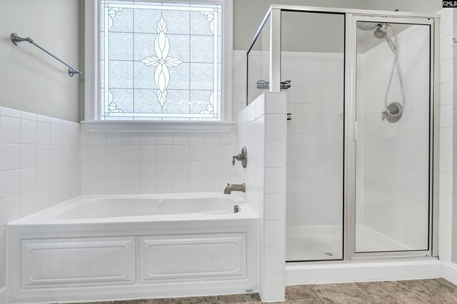 bathroom with tile patterned floors, a bath, and a stall shower