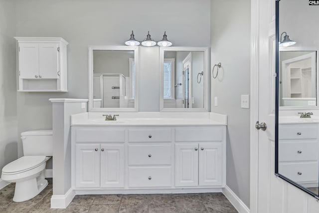 full bathroom featuring baseboards, vanity, toilet, and a shower