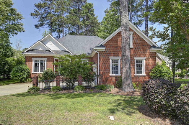 view of front of house with brick siding, a shingled roof, and a front lawn