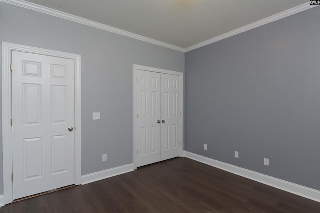 unfurnished bedroom featuring a closet, baseboards, ornamental molding, and dark wood-type flooring