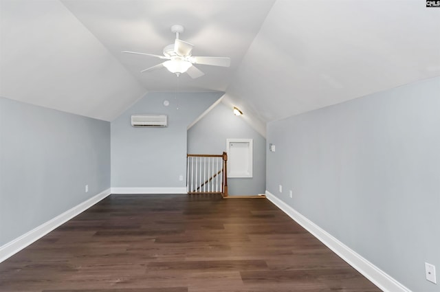 additional living space with a ceiling fan, vaulted ceiling, a wall mounted air conditioner, wood finished floors, and baseboards