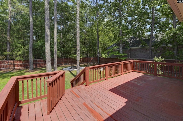 wooden terrace featuring a fenced backyard and a yard