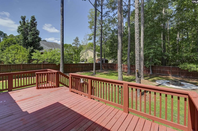 wooden terrace with a fenced backyard, a yard, and an outdoor fire pit