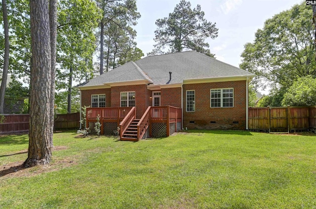 rear view of property with crawl space, a lawn, a deck, brick siding, and a fenced backyard