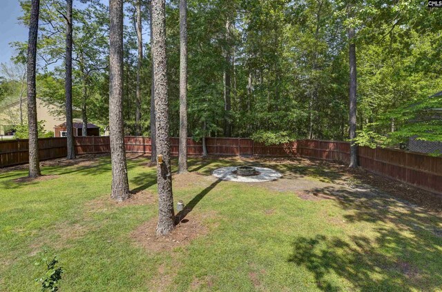 view of yard with a fenced backyard and an outdoor fire pit