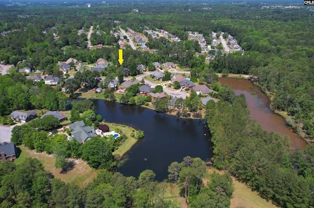 drone / aerial view featuring a forest view, a residential view, and a water view