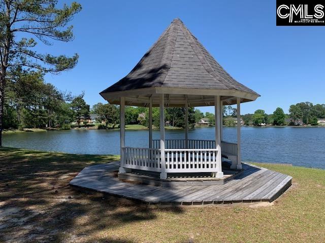 view of dock featuring a water view, a gazebo, and a yard