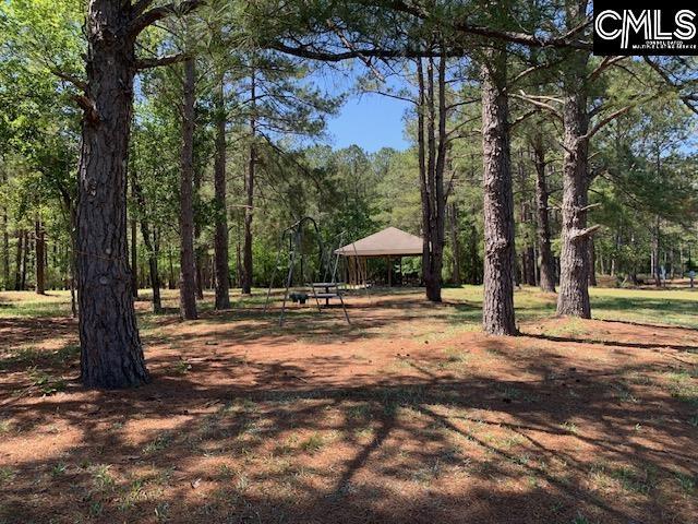 surrounding community with a gazebo and a wooded view