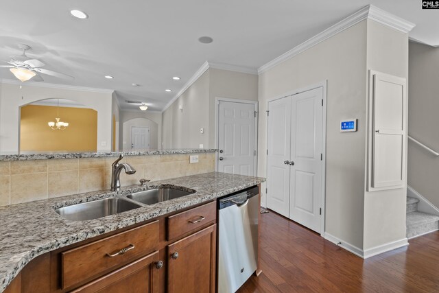 kitchen with brown cabinetry, backsplash, arched walkways, dishwasher, and a sink