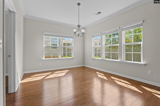 unfurnished dining area featuring crown molding, baseboards, visible vents, and an inviting chandelier