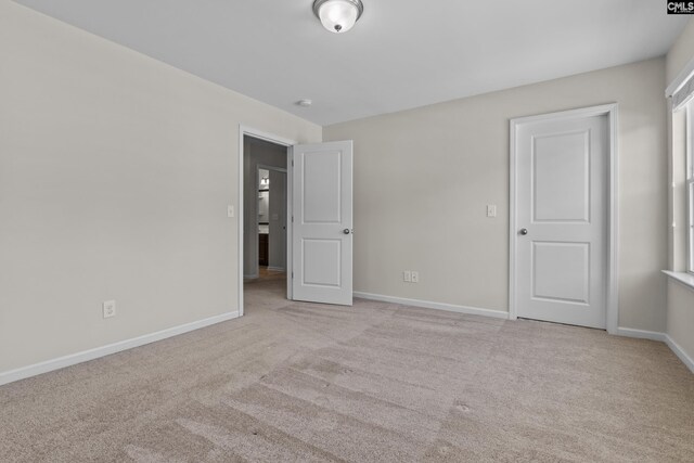 unfurnished bedroom featuring carpet floors and baseboards