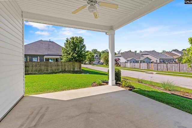 view of patio featuring ceiling fan, fence, and a residential view