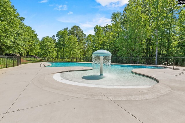 community pool with fence and a patio