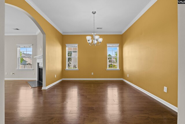 unfurnished dining area featuring visible vents, ornamental molding, dark wood-style flooring, and arched walkways