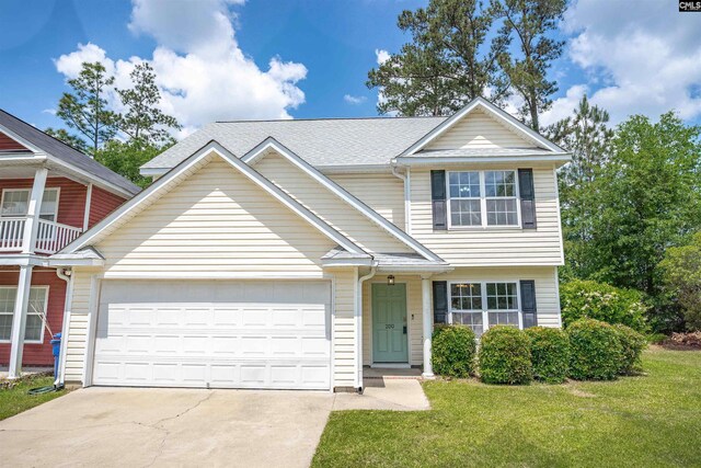 view of front facade featuring an attached garage, a front lawn, and driveway