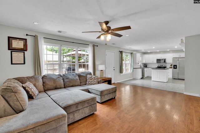 living area featuring recessed lighting, light wood-style floors, and ceiling fan