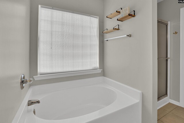 bathroom featuring plenty of natural light, a shower stall, and a bath