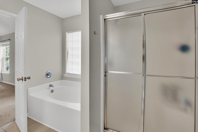 bathroom with baseboards, tile patterned flooring, a stall shower, and a bath