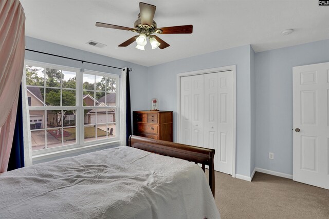 carpeted bedroom with baseboards, visible vents, ceiling fan, and a closet