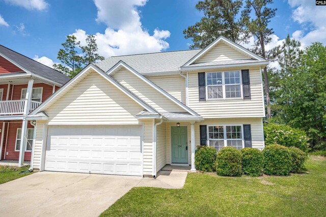 view of front of house with an attached garage, a front lawn, and driveway