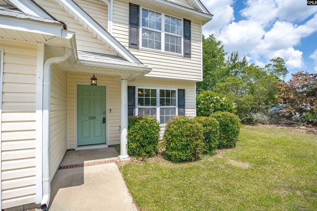 property entrance with a lawn